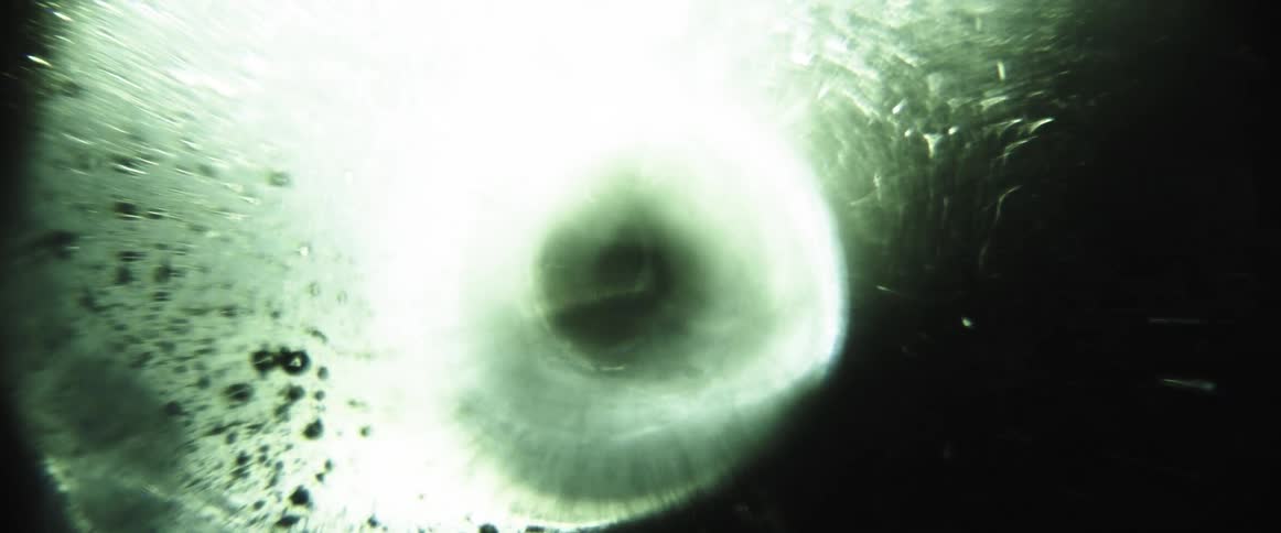 Burst of white light in the midst of darkness creates a scattering effect with visible particles