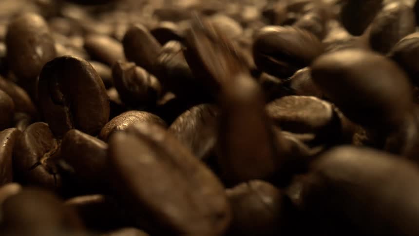 Roasted coffee beans falling into a pile