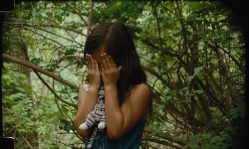The little girl is covering her face