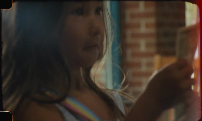 Based on the video a closeup shot shows a persons hands holding and folding money the scene has a vintage film effect with some dust and scratches visible