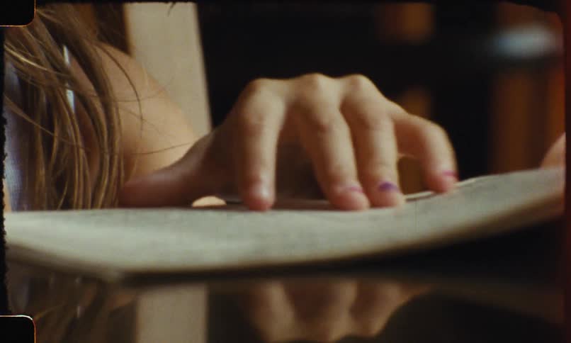 A closeup of a child eating a snack and intently looking at a book