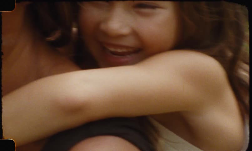 Smiling mother carrying her daughter on her back while she laughs joyfully