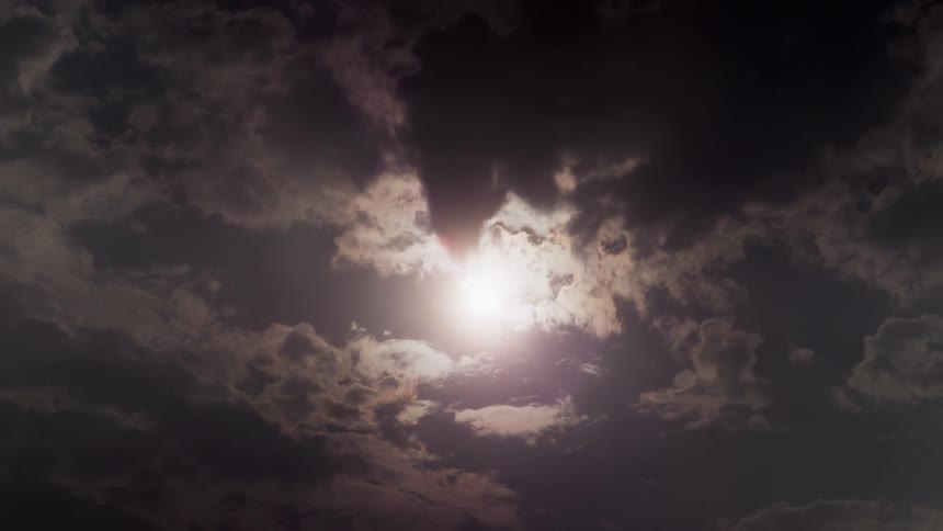 Dark clouds move across the sky covering the sun