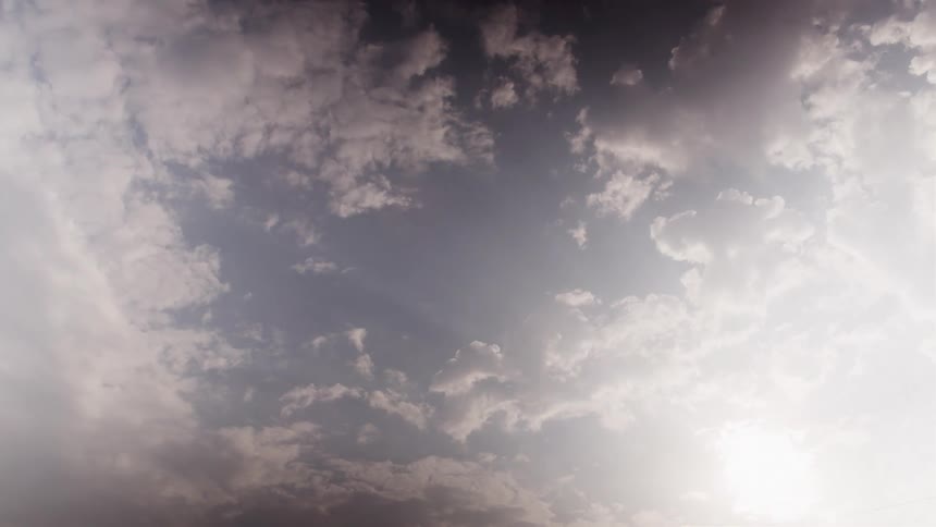 Partly cloudy sky with rays of sunlight in the background