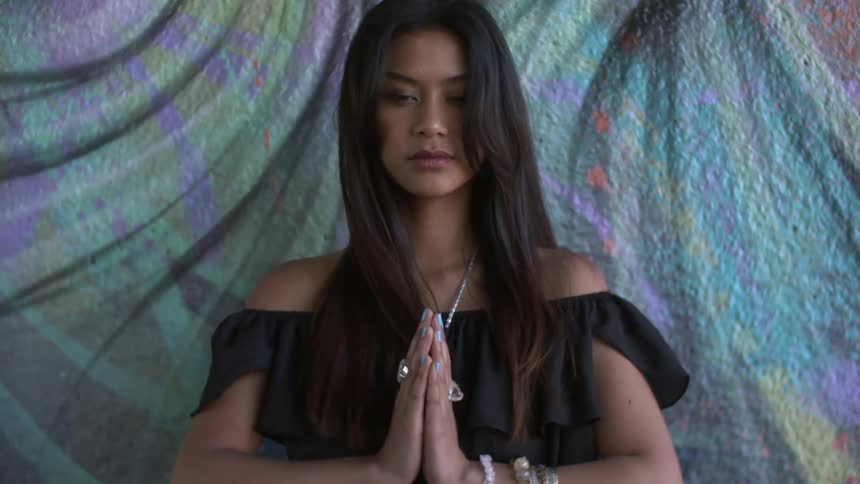 Woman holding her hands together looking down