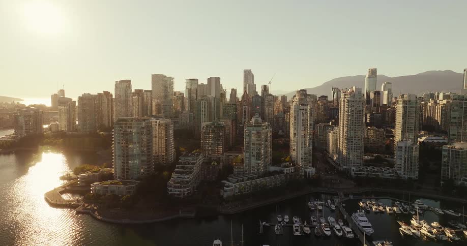 Aerial view of city skyline with marina at sunset