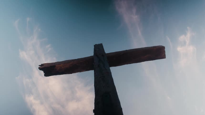 A wooden cross stands tall against the sky