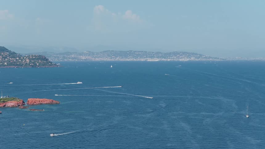 Boats sailing on blue sea with a city in the background