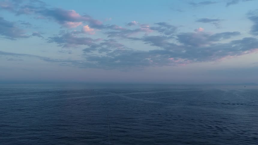 Sailboat sails alone on the sea during sunset