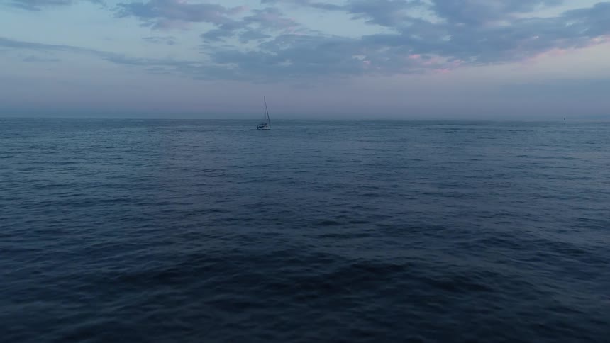 Water ripples and waves with a boat sailing on the horizon