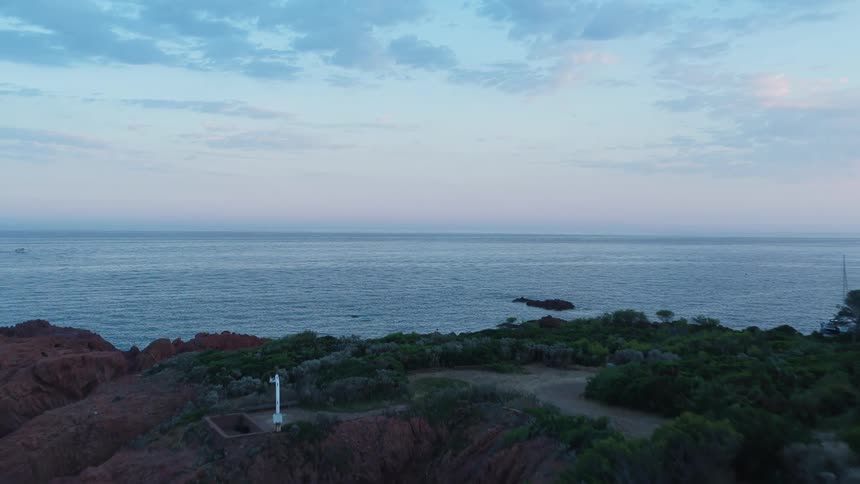 Stone house isolated on a seaside cliff at sunset