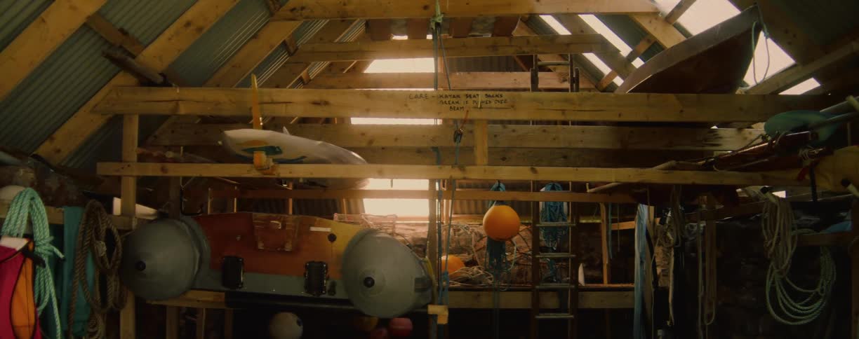 A wooden boathouse interior with rustic walls and beams