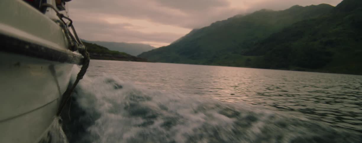 Water splashes as a boat sails on a river in the mountain valley