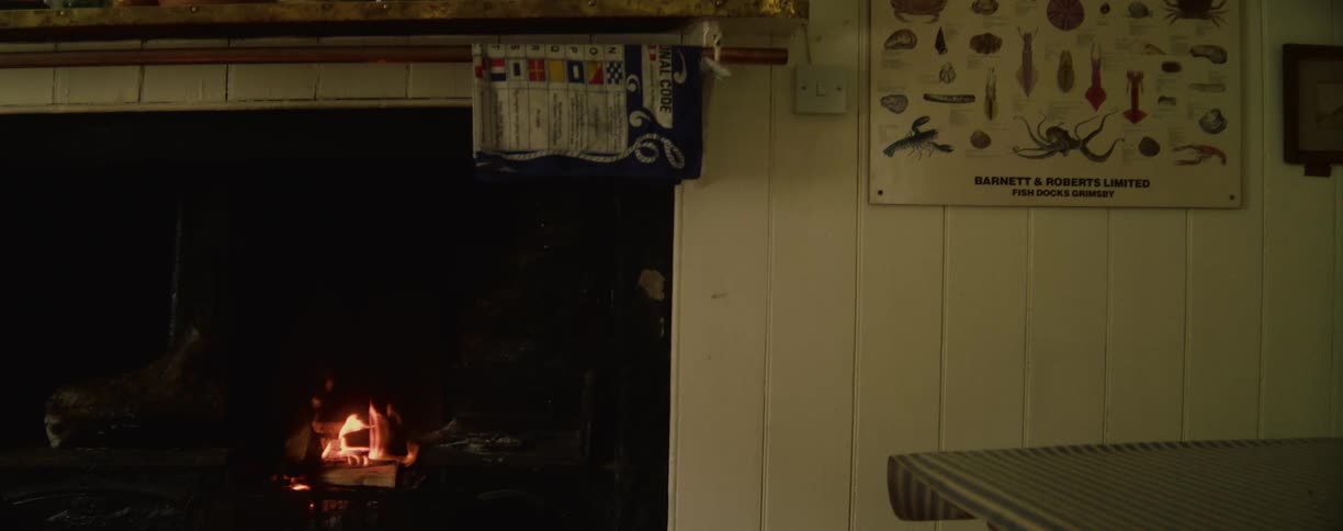 A small fire burns in a cozy cottage fireplace
