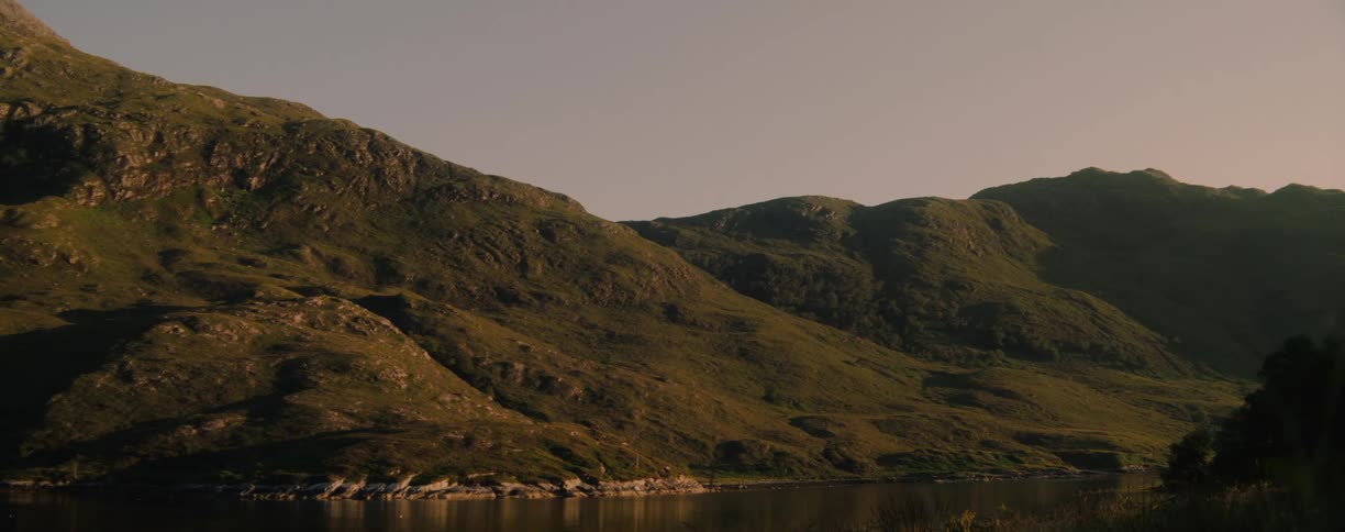 Sunlight shines on mountains along the coast of a river valley