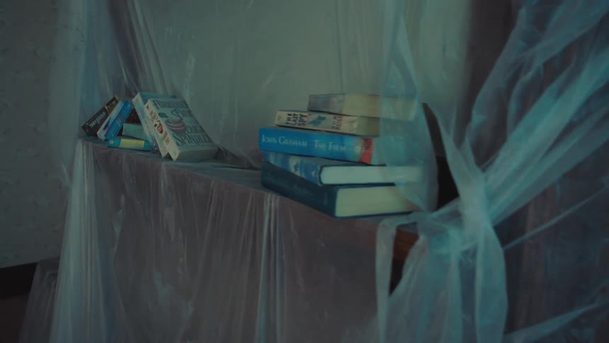 Stacked cardboard boxes next to a window covered with translucent plastic