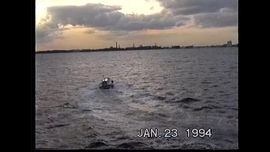 Boat sails leaving a wake on the water at sunset