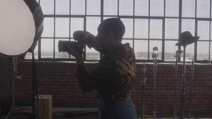Photographer shooting with large windows and lights in a studio