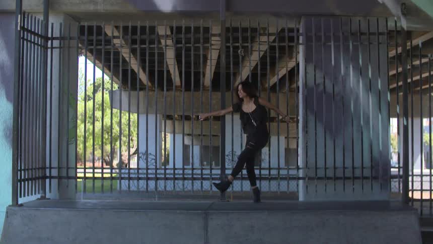 Woman leaning against a gate