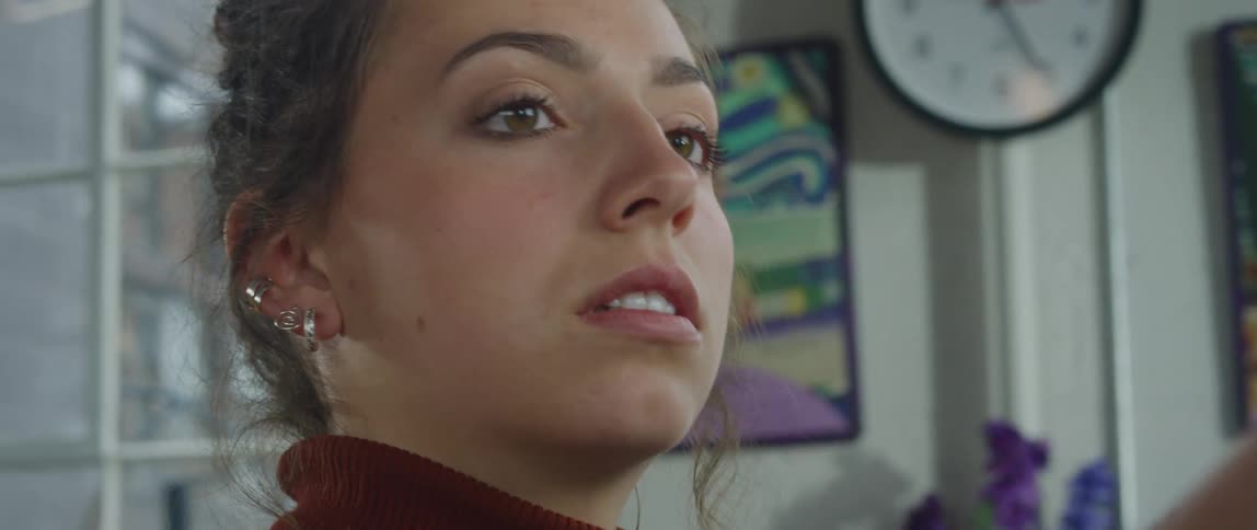 A female artist painting on a canvas inside a studio at midday