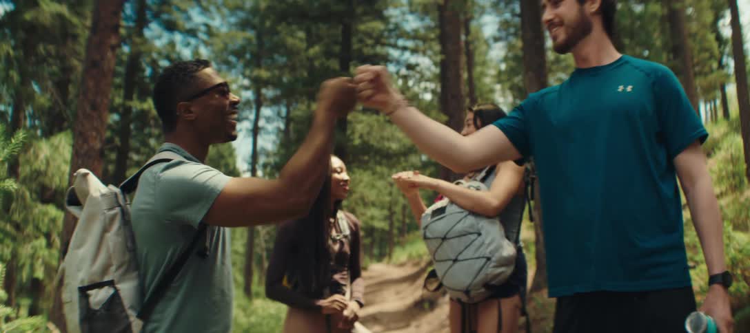 Friends talk and fist bump on the hiking trail