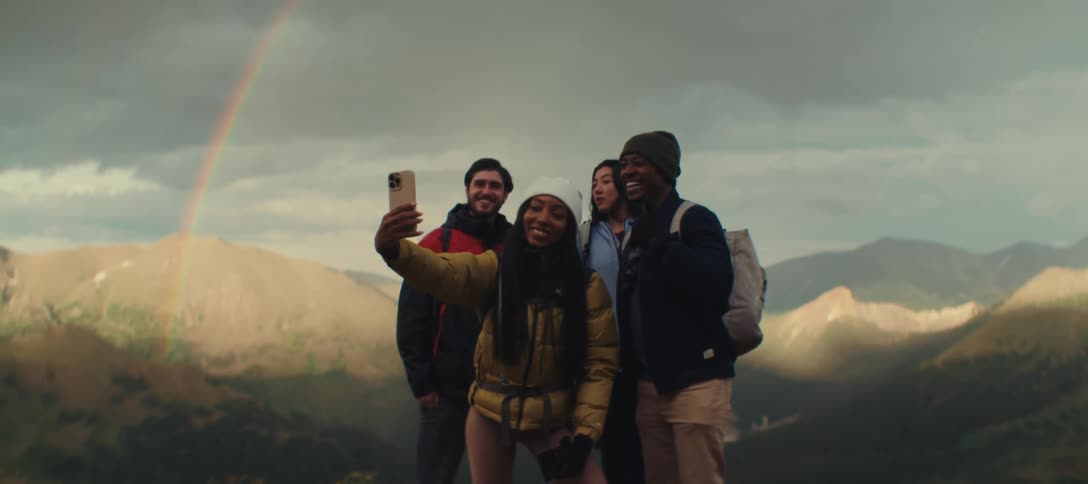 Friends taking a selfie on mountain top with smartphone