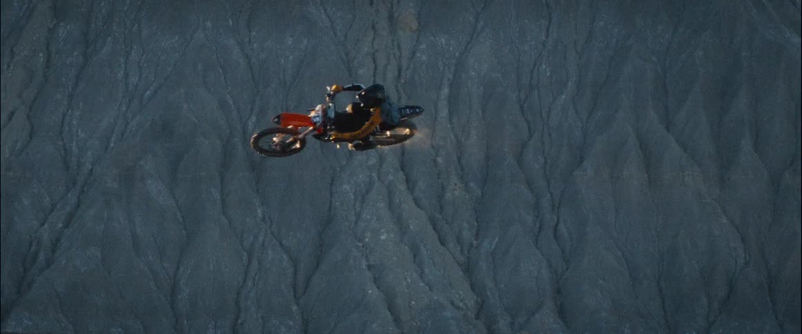 Motorcyclist performs an aerial jump over rocky terrain