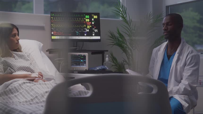 A doctor consulting a patient in a hospital room