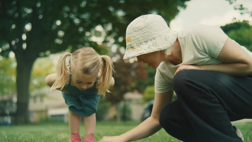 A mother and child spend time together outdoors on the lawn