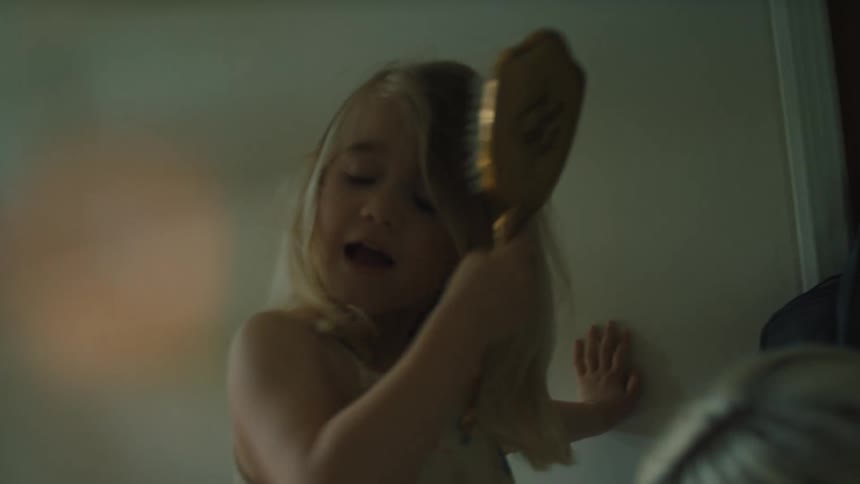 Mother putting boots and backpacks on her little daughter