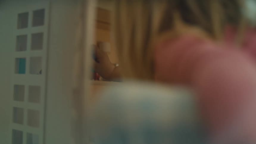 A girl plays with her doll house
