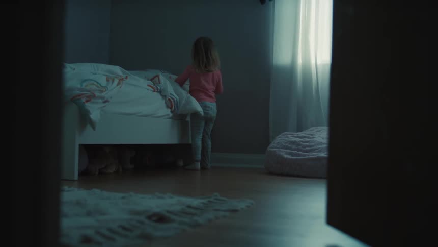 The girl gets up and walks from her bed