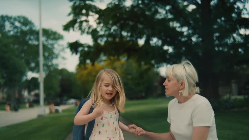 A mother walks her daughter home from school