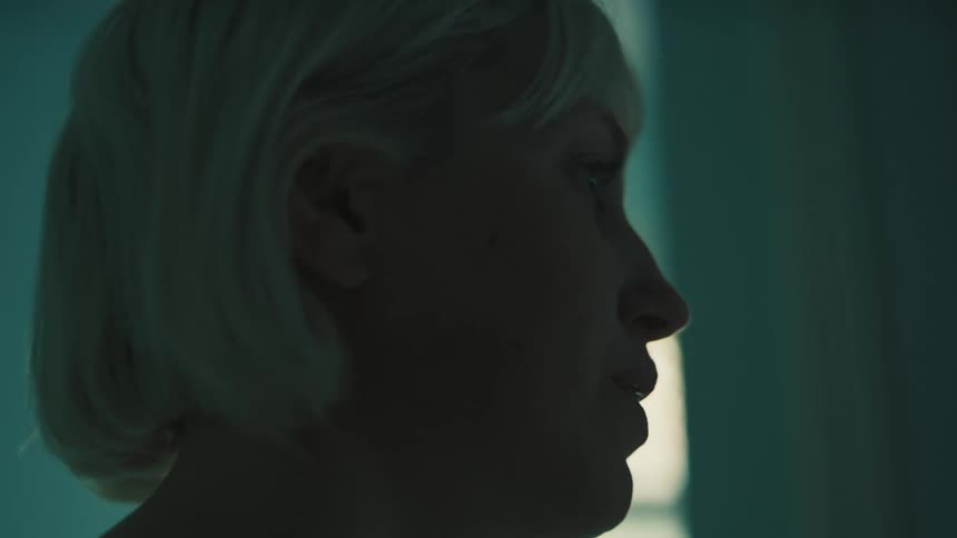 The woman wipes her chin with her hand