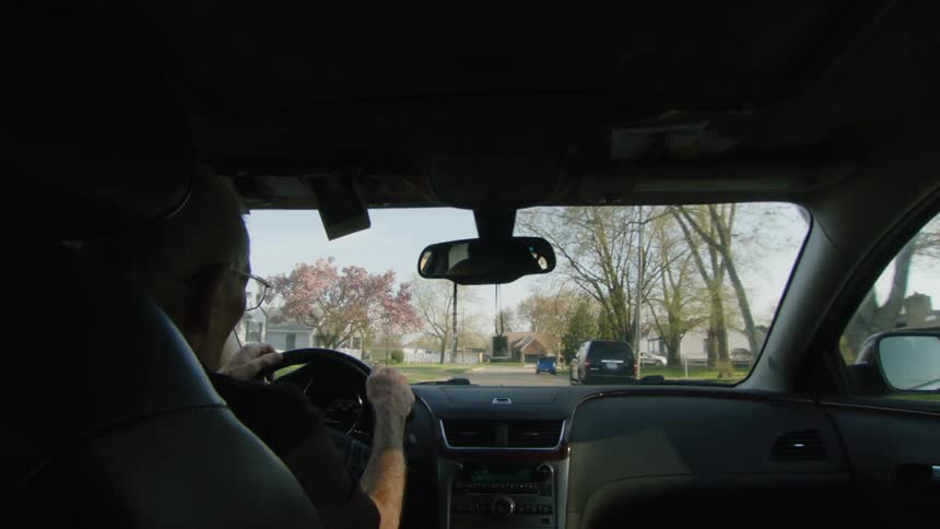 A man driving down a suburban street