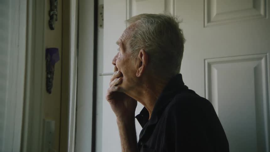 A man is smoking in the doorway