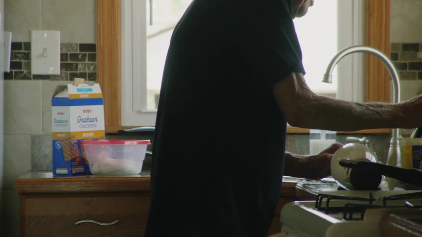 The man is doing dishes at home