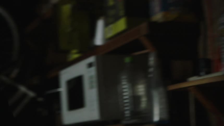The man smokes as he turns the lights off in his garage