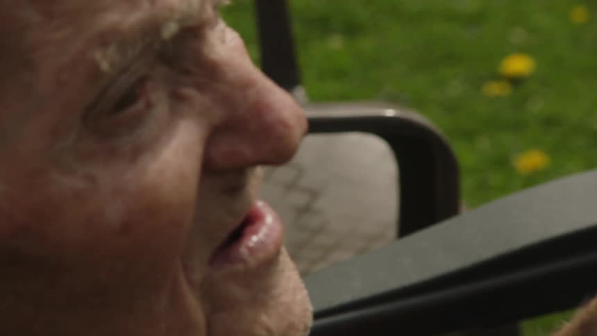 Elderly man sitting holding a phone