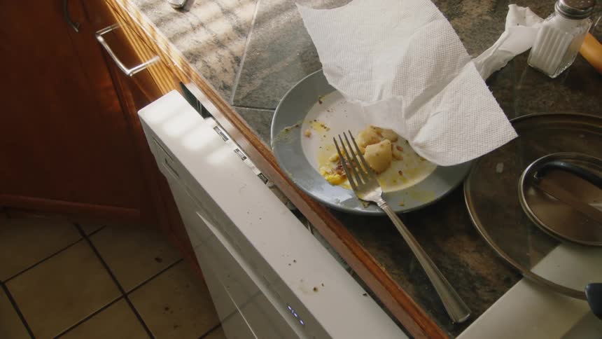 A plate with scraps of food and a napkin on a kitchen counter