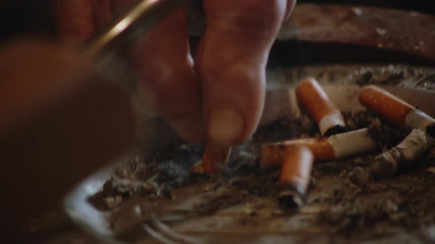 cigarette video Smoker crushes a burning cigarette in an used metal ashtray
