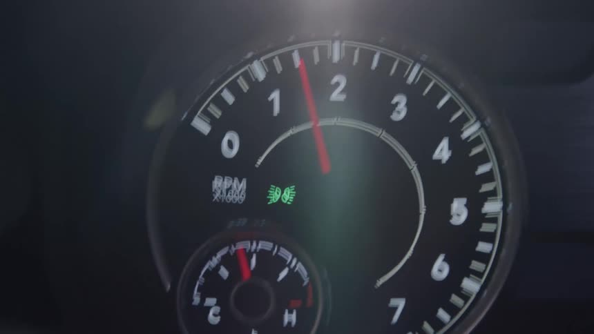 The video shows a closeup of a cars dashboard with the rpm gauge and other indicators visible the red needle on the rpm gauge rapidly moves from 0 to over 4 then quickly drops back down