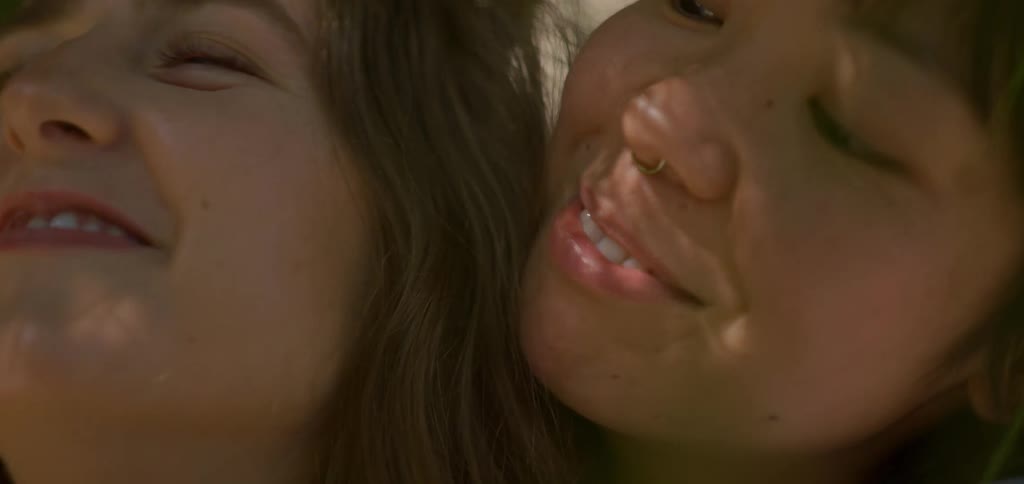 Two teenage girls standing next to each other smiling