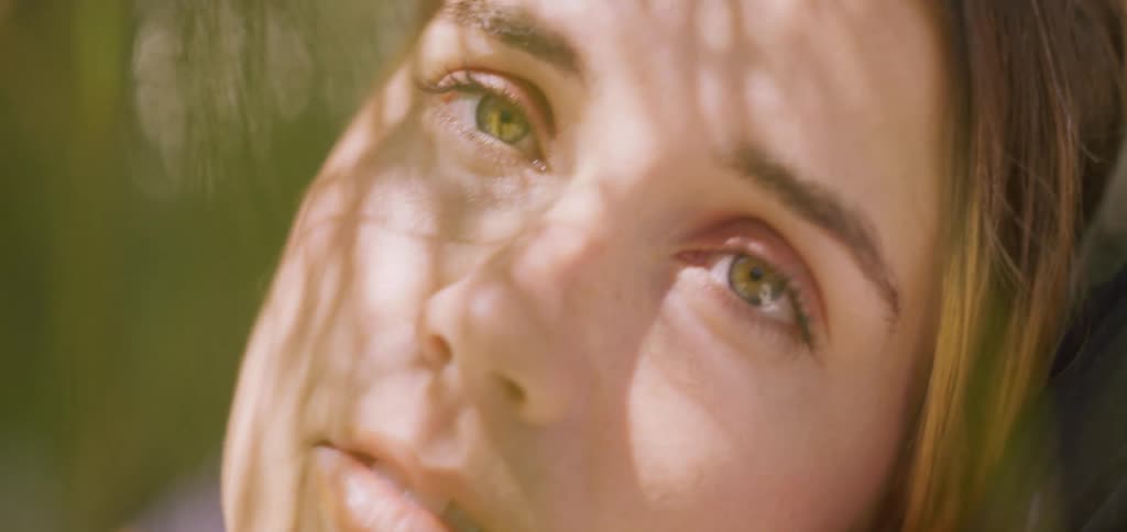 A woman with a restful expression as the sun falls on her face