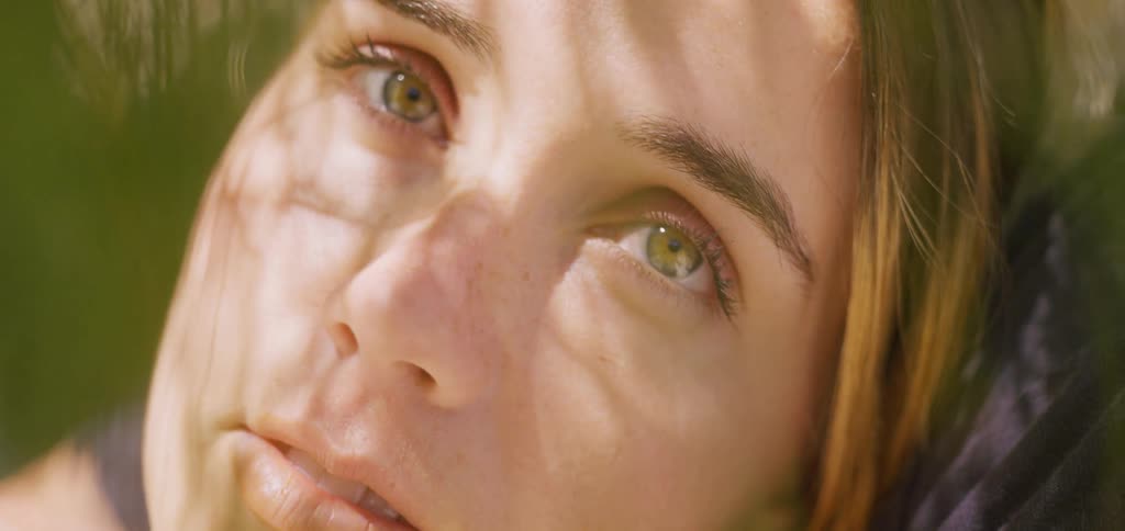 The video shows an extreme closeup of a persons hand drawing on a tablet or electronic device in the dark the faint glow of the screen and a small red indicator light are the only sources of illumination creating a lowlight intimate view of the crea