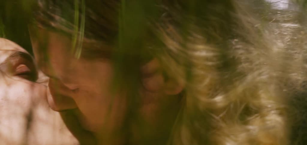 A couple kisses each other romantically at midday under the sun