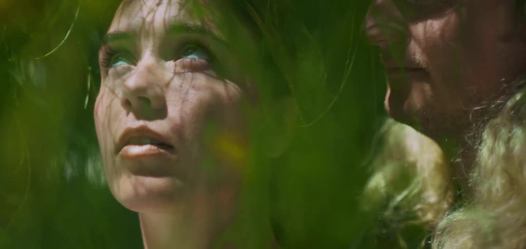 Woman and a man among the green leaves of a tree