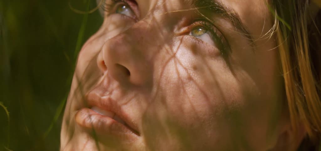 Womans face with reflection of light and leaves of a tree
