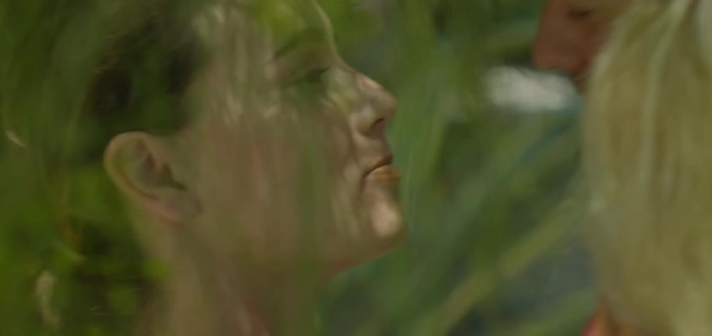A man and woman kiss in the forest