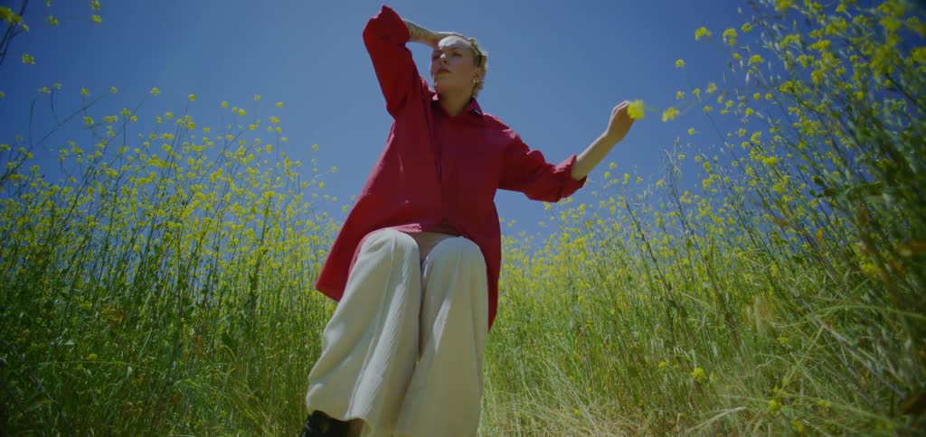 Woman dancing in a field with yellow flowers